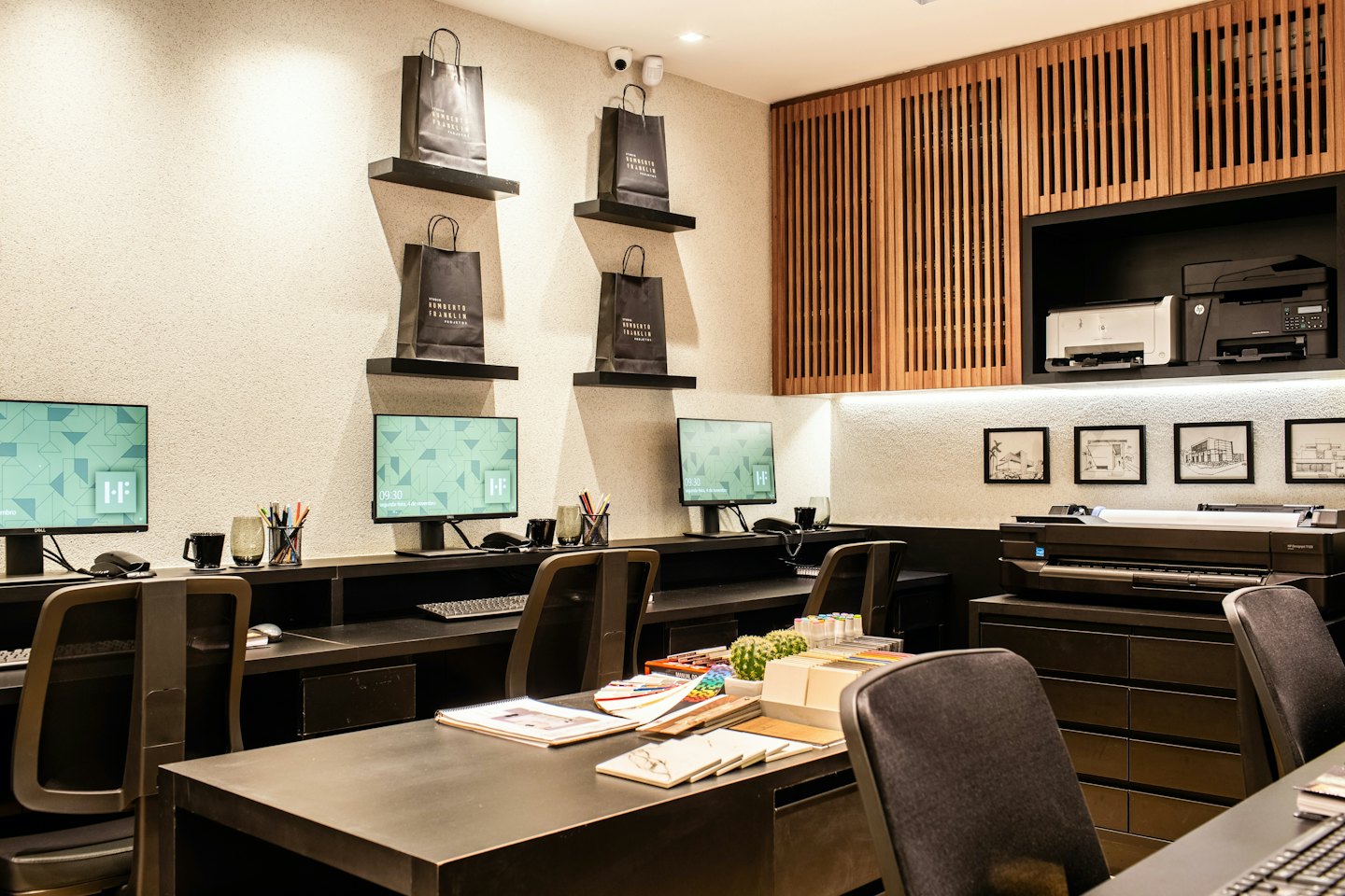 Modern office workspace featuring computer stations and branded shopping bags.